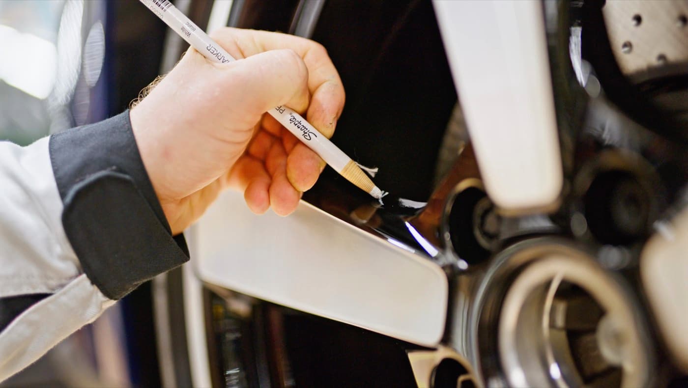 Operator performing an in-process quality check on a Porsche production line as part of an in-line inspection workflow.
