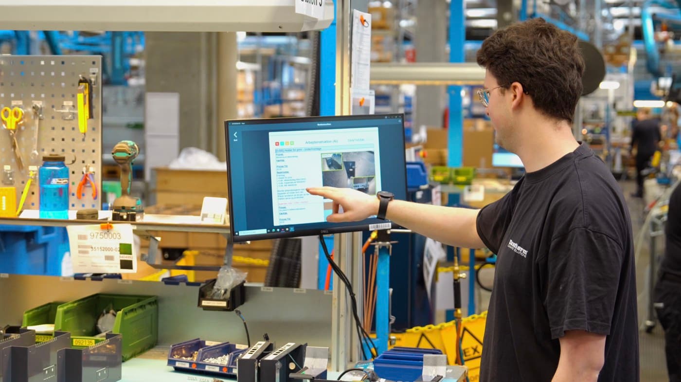 Operator reviewing photo-based digital work instructions on a shopfloor terminal