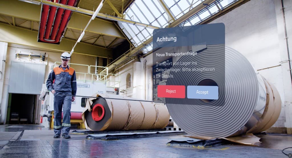 Worker receiving a logistics transport request alert in the warehouse