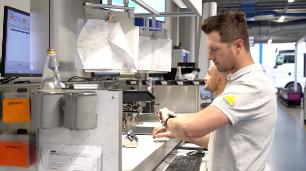 Bediener prüft Arbeitsanweisungen per Smartwatch am Maschinenbetriebs-Arbeitsplatz