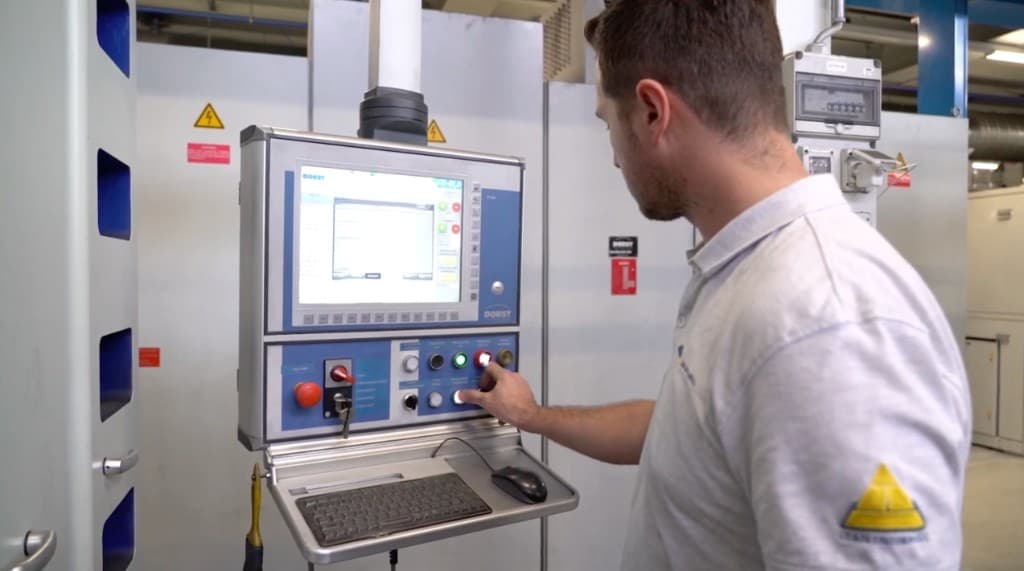 Maintenance technician operating an industrial control panel at the machine