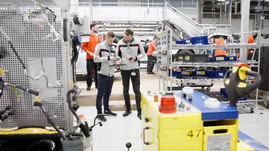 Shopfloor managers reviewing production data on a tablet at the assembly line